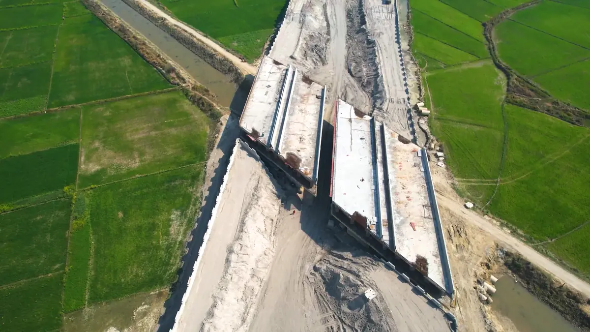 Drone view of a highway bridge under construction across a canal