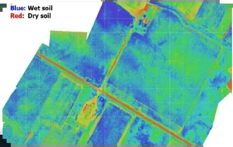 Drone map of farmland coloured from wet soil in blue to dry soil in red, with a canal crossing the fields